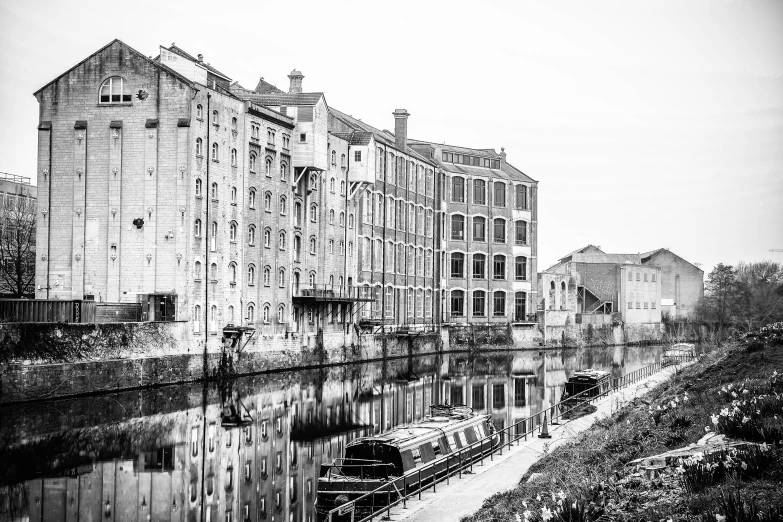 black and white po of some very old buildings by the water