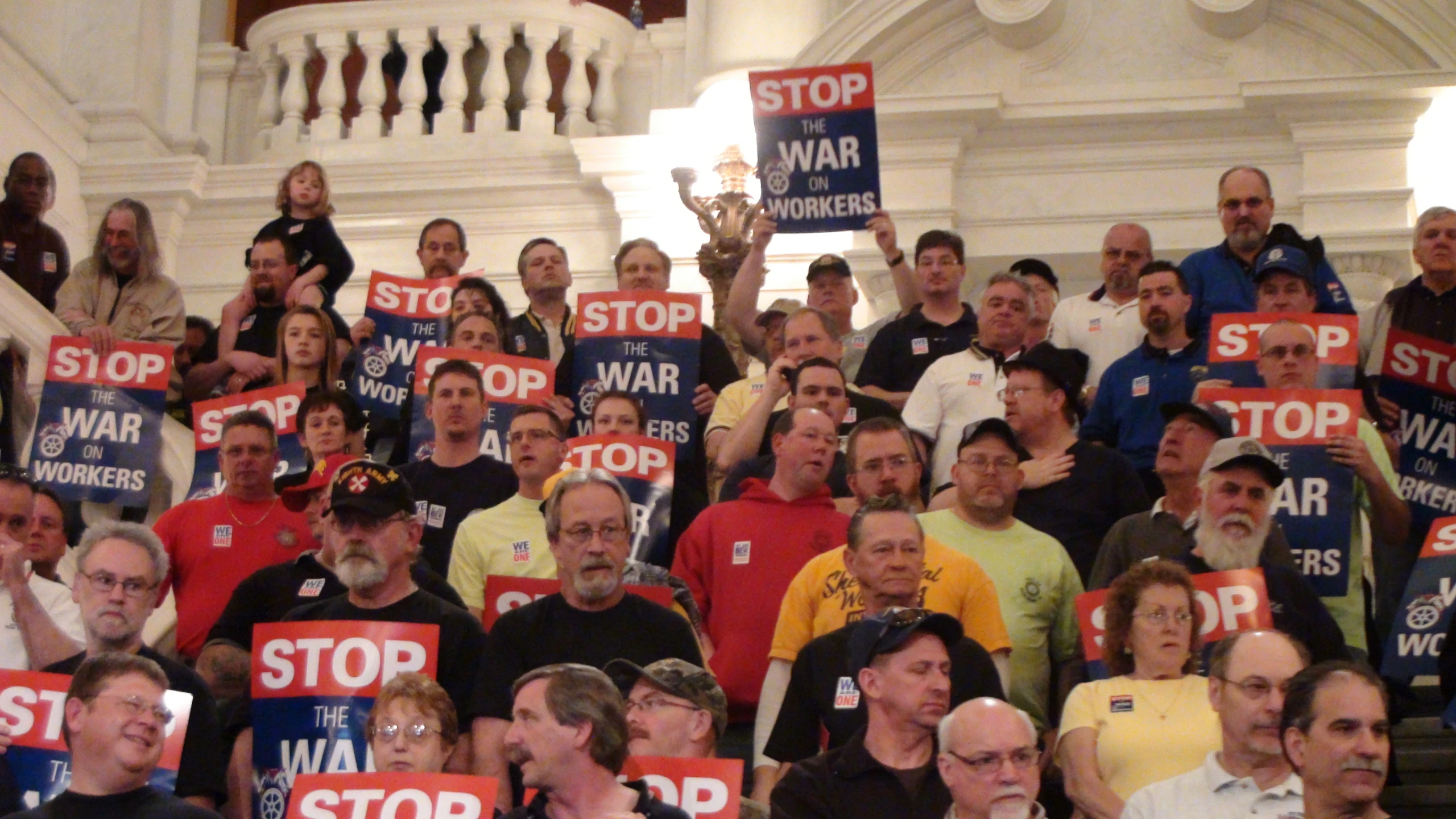 a group of people with signs are standing on the floor