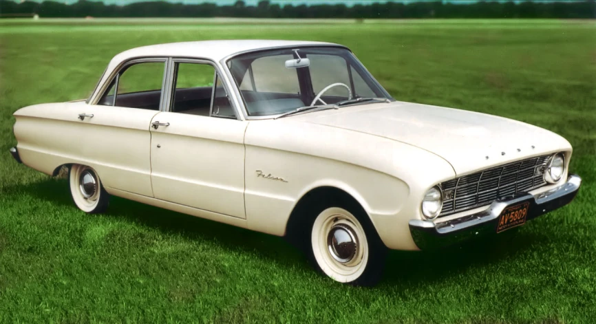 a small white car parked in the grass