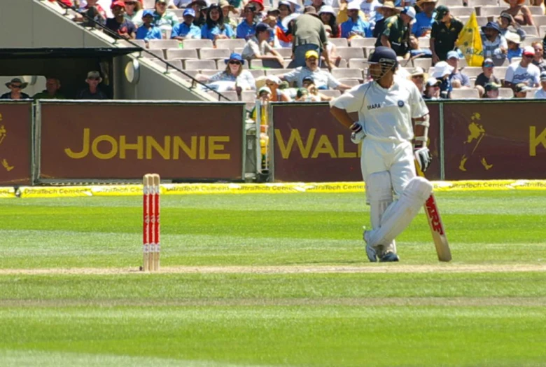 a person on a field playing a game of cricket