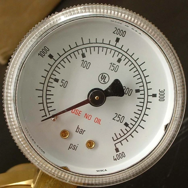 an analog pressure gauge attached to the side of a gold stand