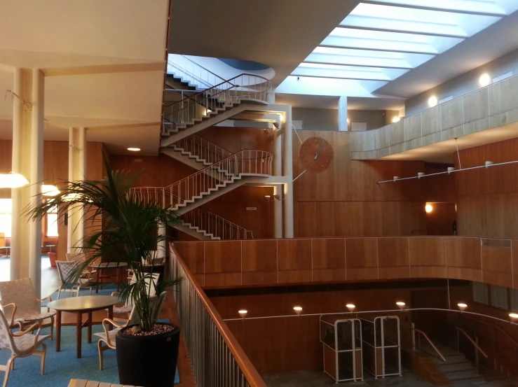 an indoor atrium that features stairs and circular tables