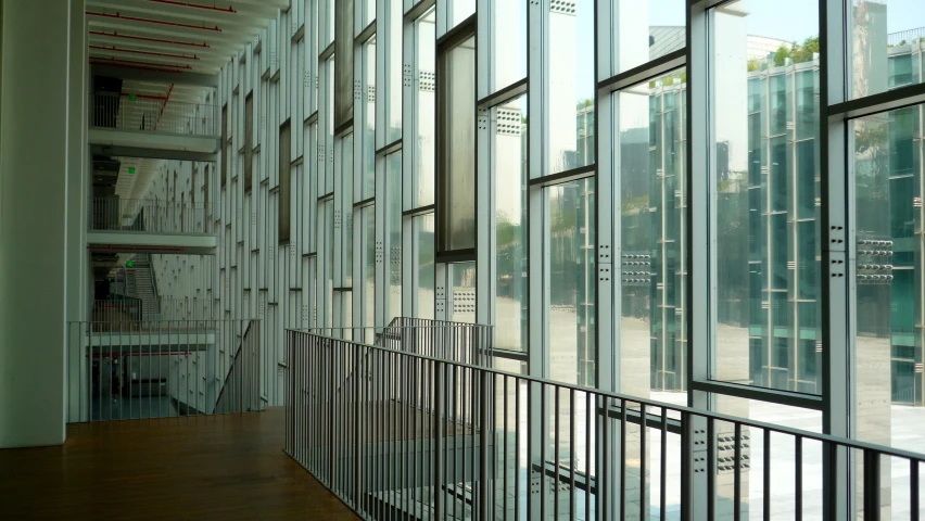 large bookshelf next to glass enclosed walkway inside building