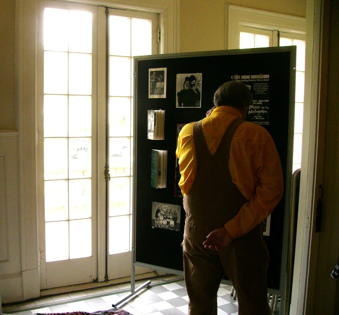 a man standing in front of a framed poster