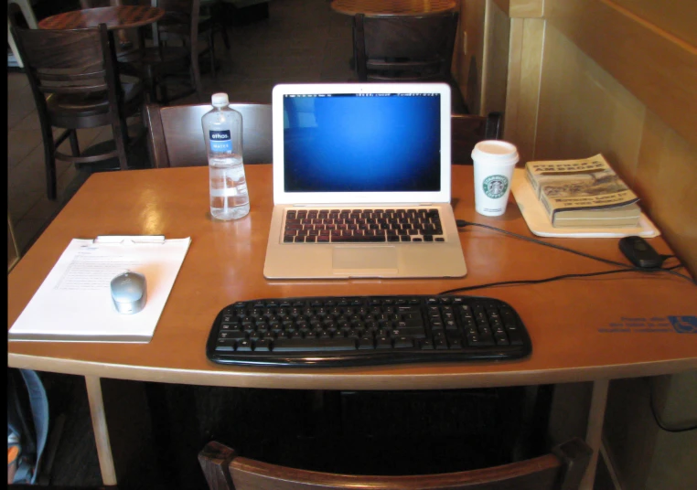 a wooden table with a laptop computer and keyboard on top