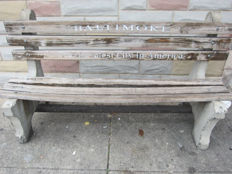 an old park bench on a sidewalk near a building