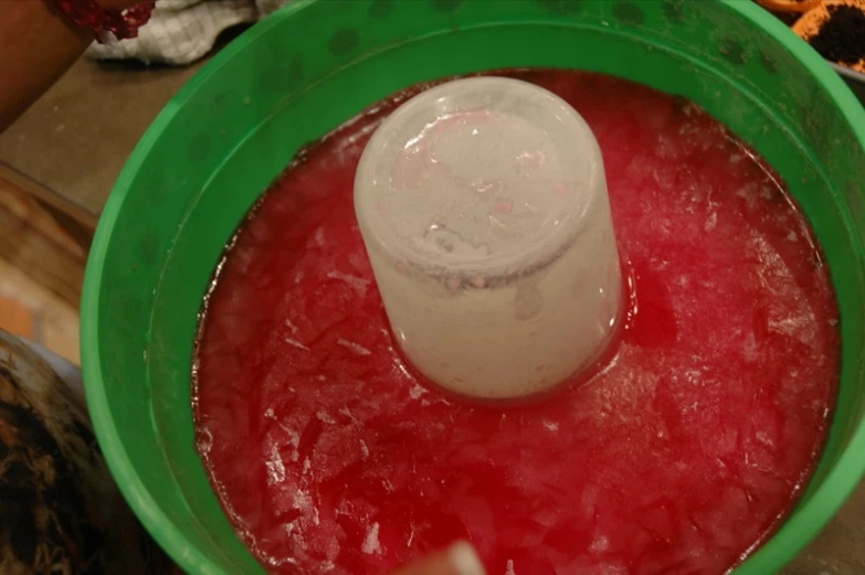 a green blender filled with liquid in a green container