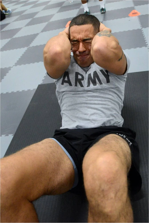 a man sitting on a mat has his hand in his hair