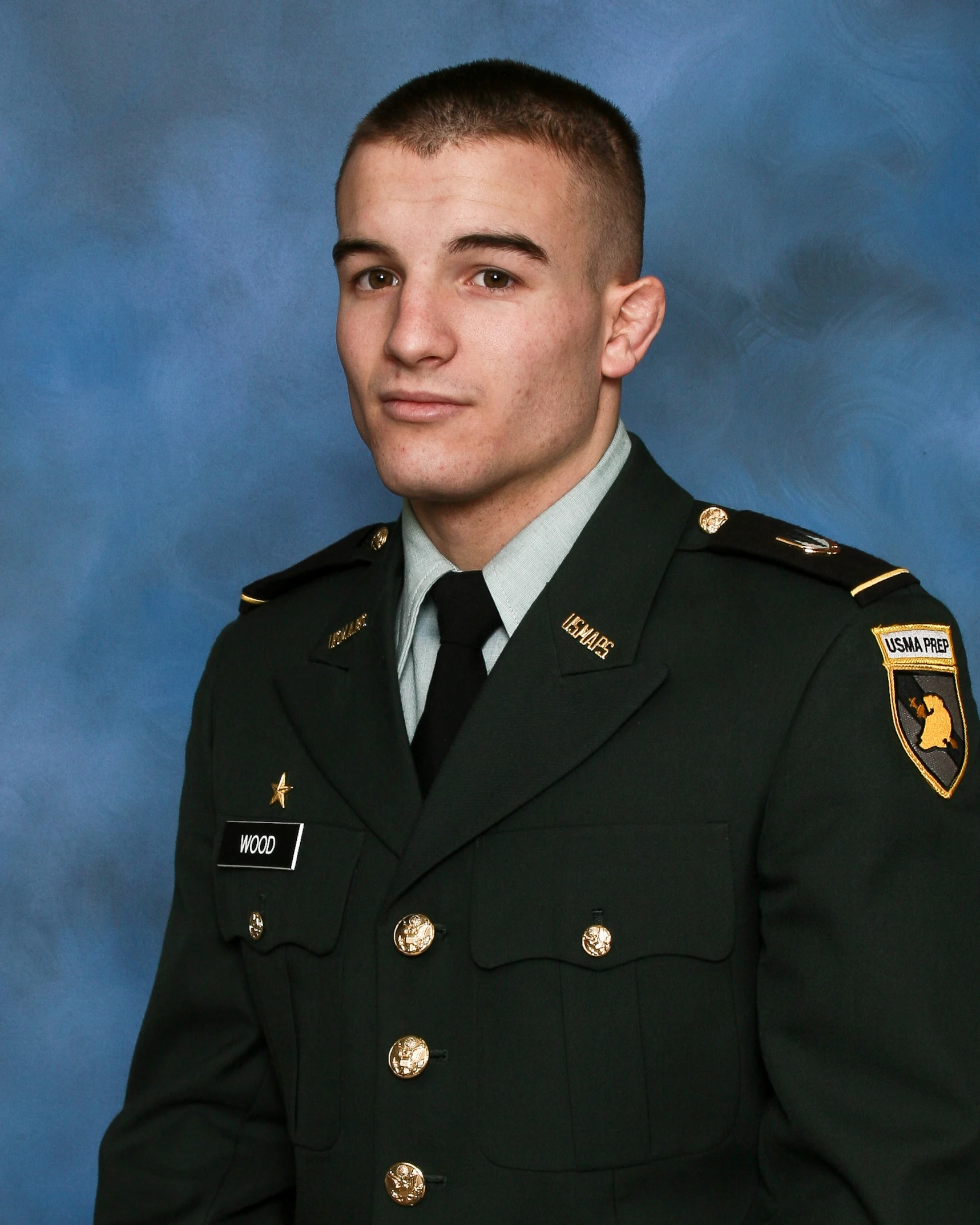 a young man in his army uniform is posing for a picture