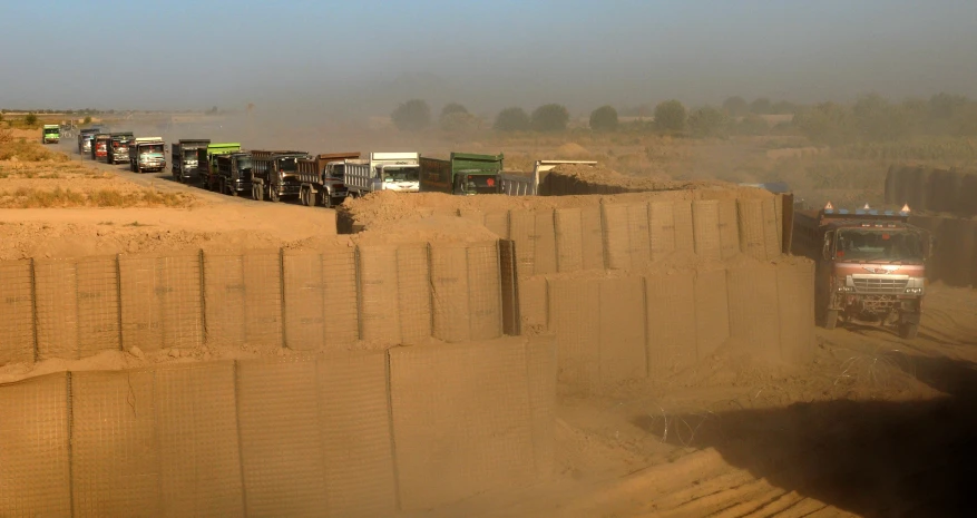 a truck drives by a section of sand wall
