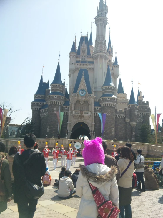 a girl in bunny ears walks in front of the castle