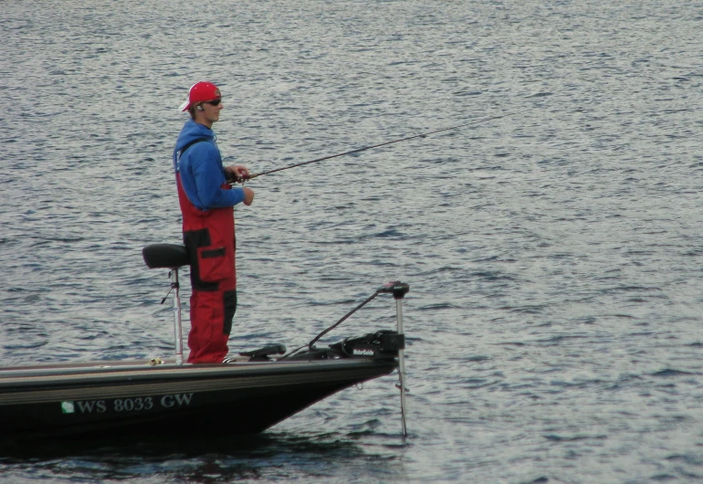 a man standing on a boat with a fishing rod