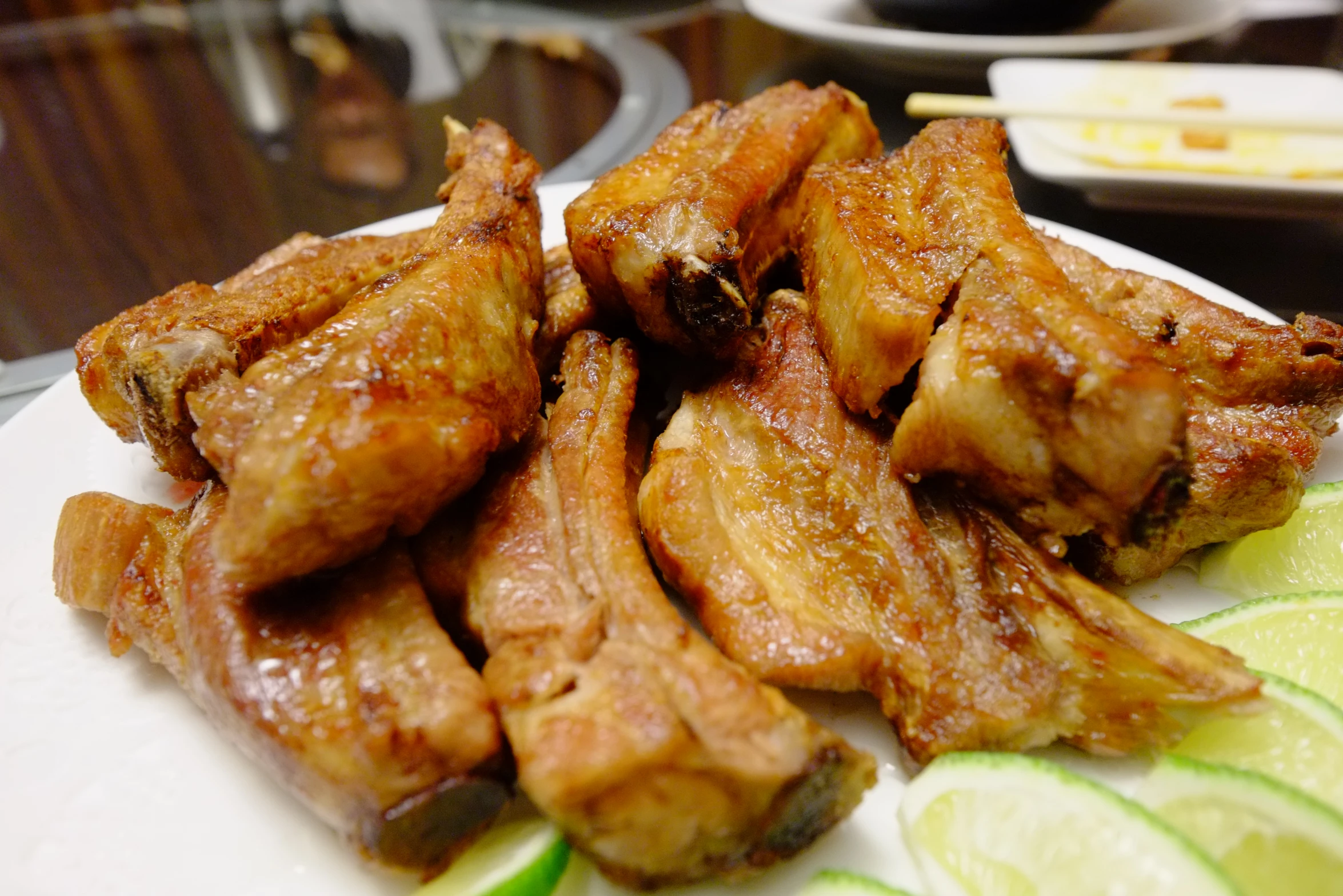 a plate of chicken wings with cucumbers on a table