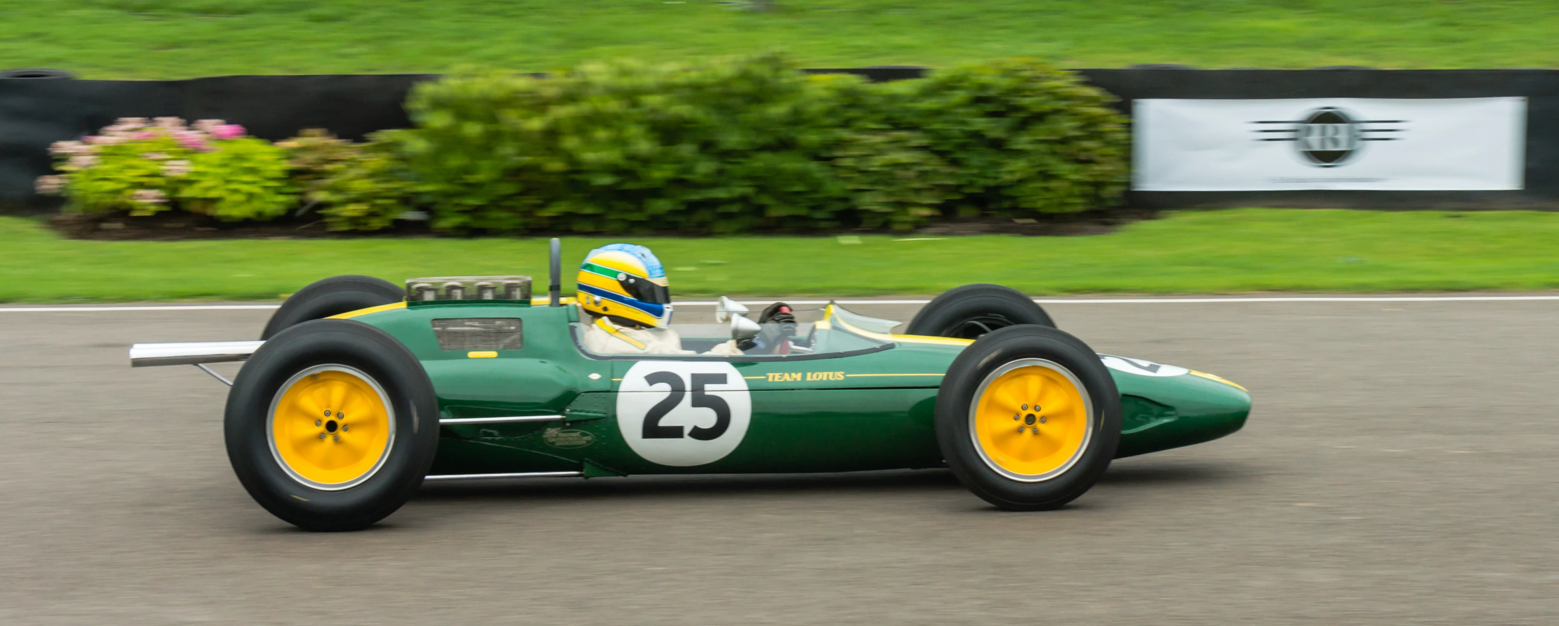 a car driving on a race track with a yellow front tire