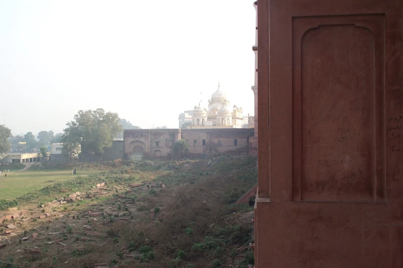 an old building sits along the side of a muddy trail