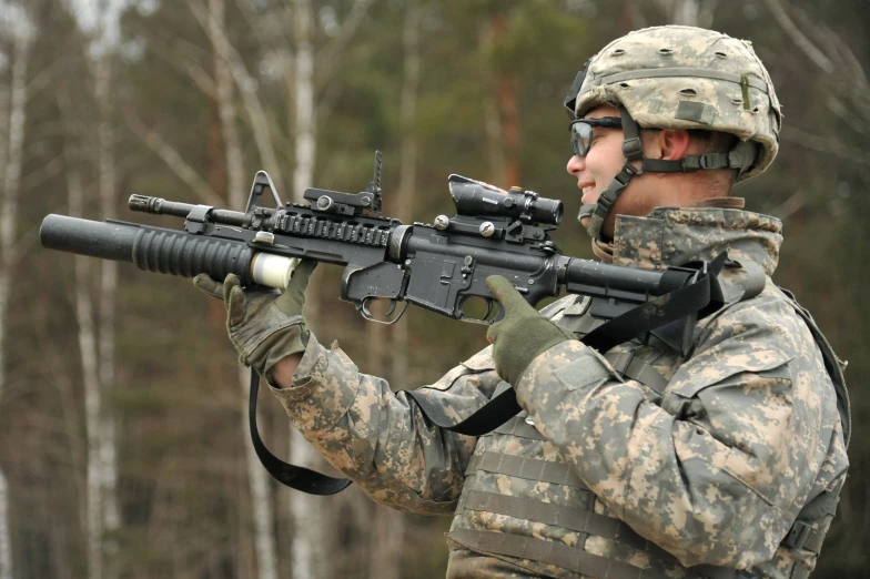 a soldier in camouflage holding an ar - 50 rifle