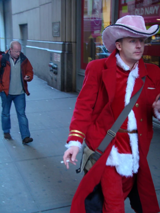 man in santa clause outfit on sidewalk with skateboard