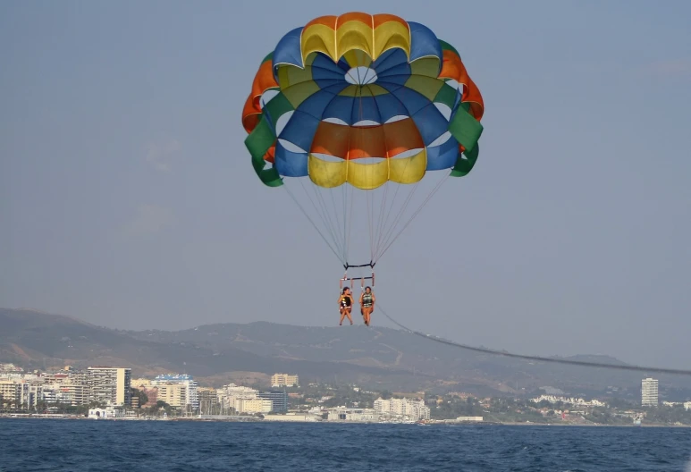 the person is flying through the air on his parachute