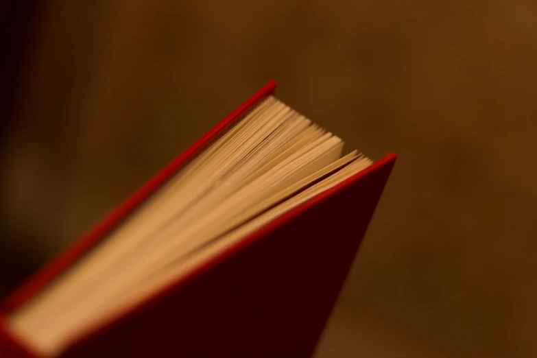 a red book sitting on top of a table next to a window