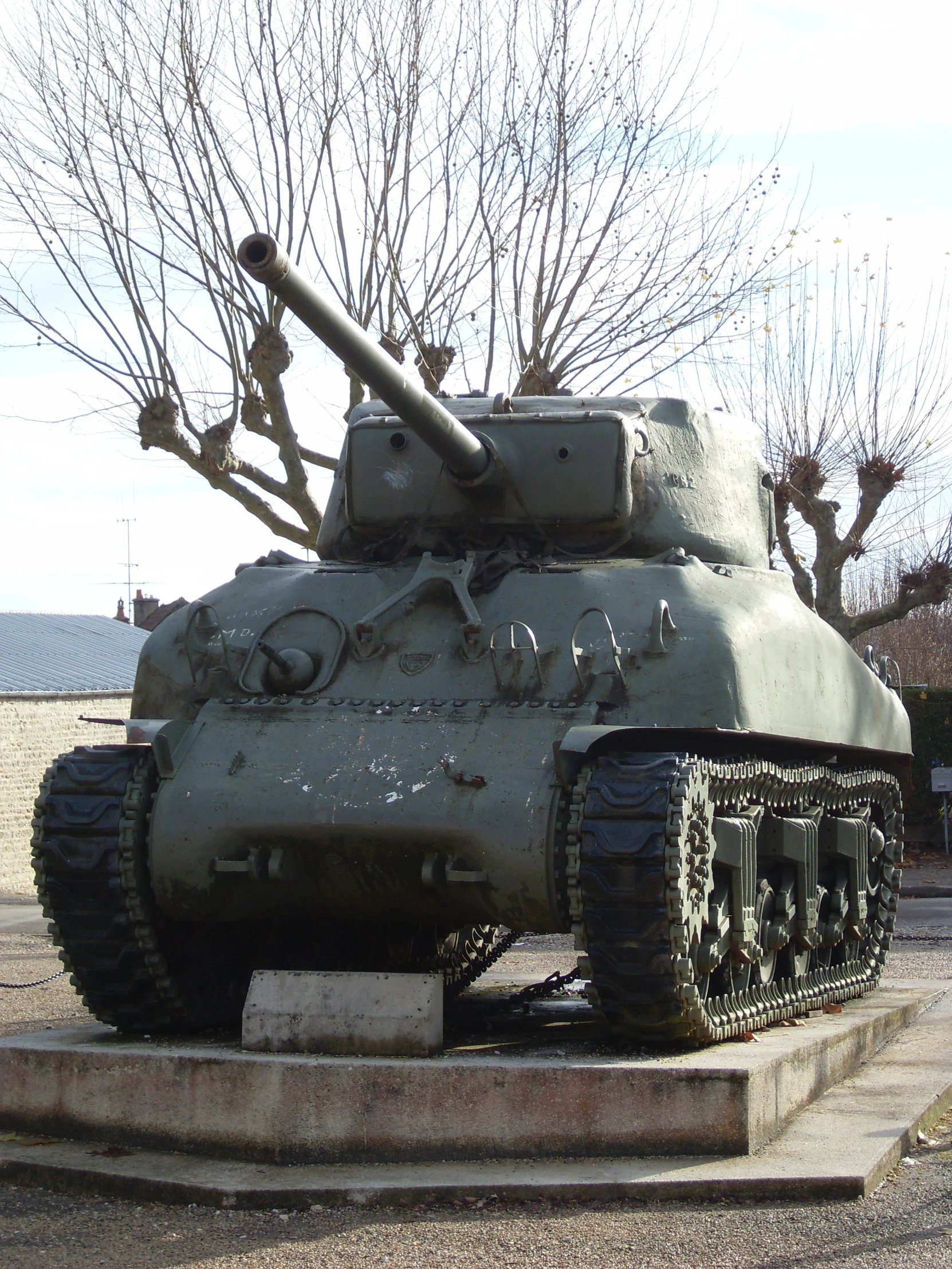 a large grey tank parked on top of a cement platform