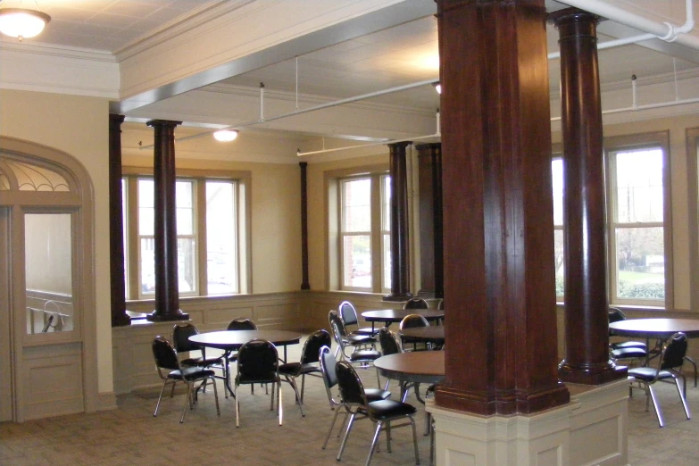 the restaurant has tables, chairs and two large pillars