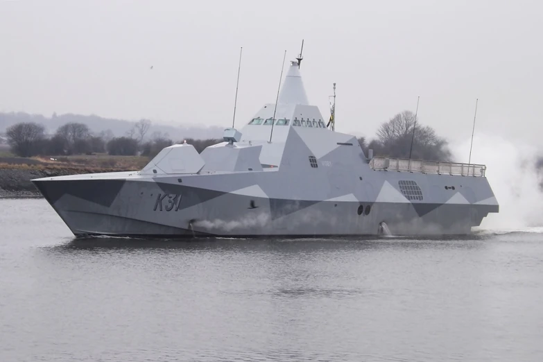 a military boat traveling down the water, with smoke coming out of it's exhaust