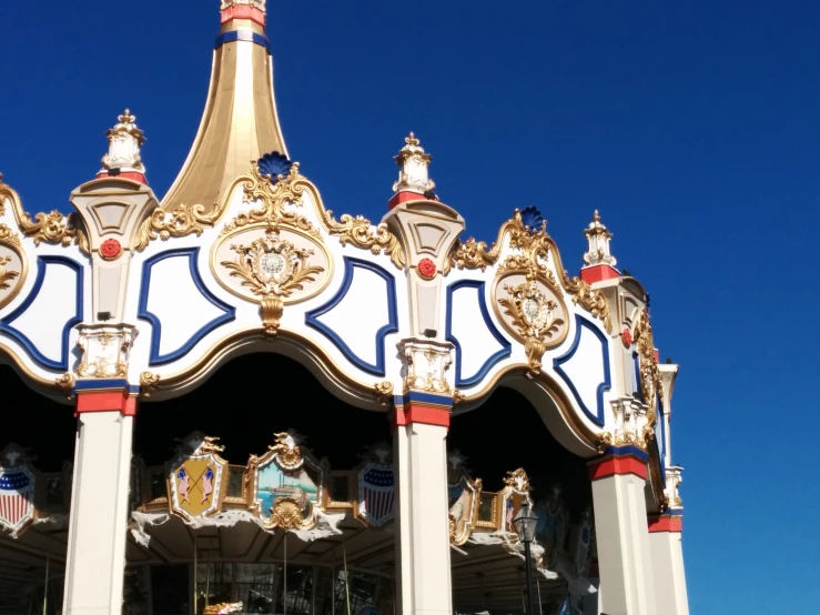 a carousel has gold decorations on the top of it