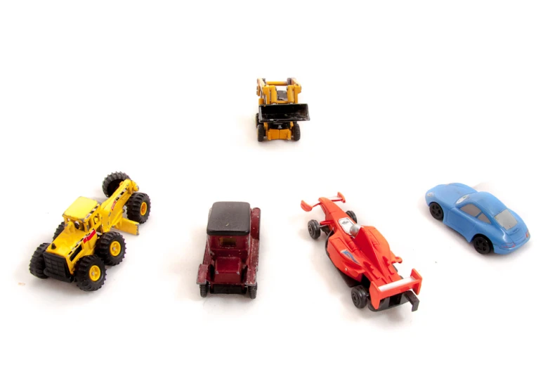 different toy trucks and tractors with a tractor in the background