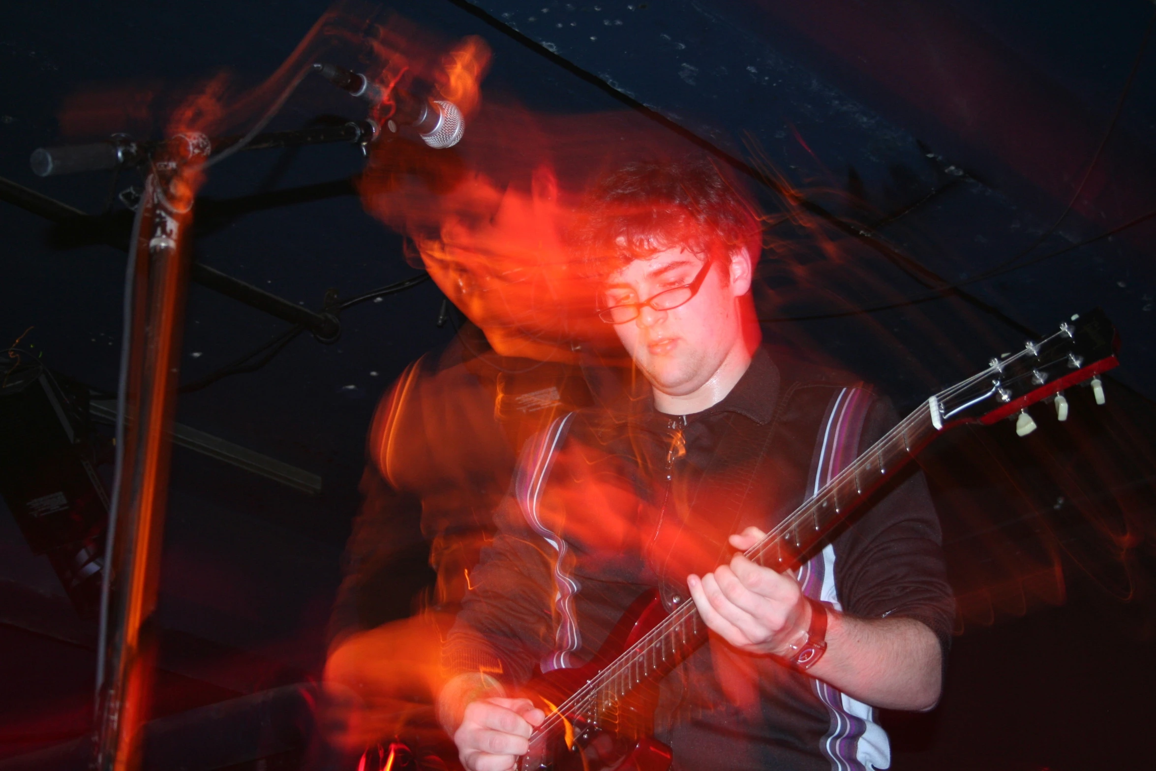 man in black shirt playing guitar on stage