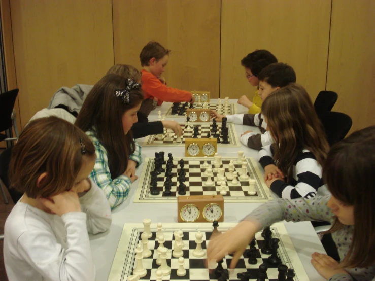 a group of people sitting at a table with chess