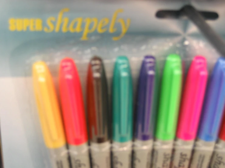 five colored pens in plastic pouch next to a metal scissors