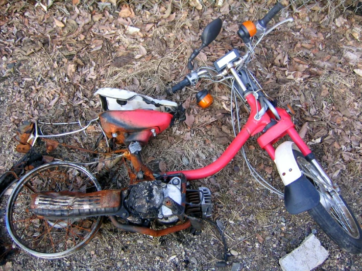 a broken and rusted bike sitting on the ground