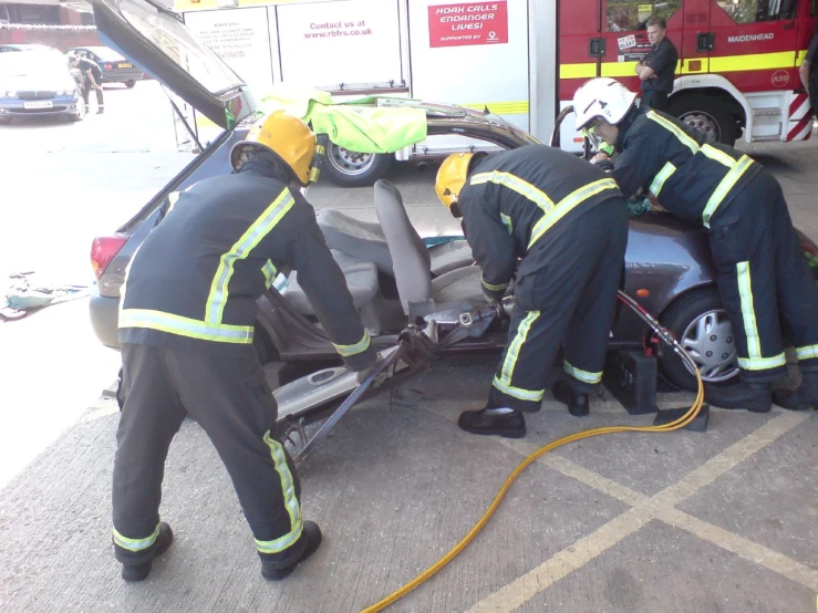 firemen performing rescue work on car in parking lot