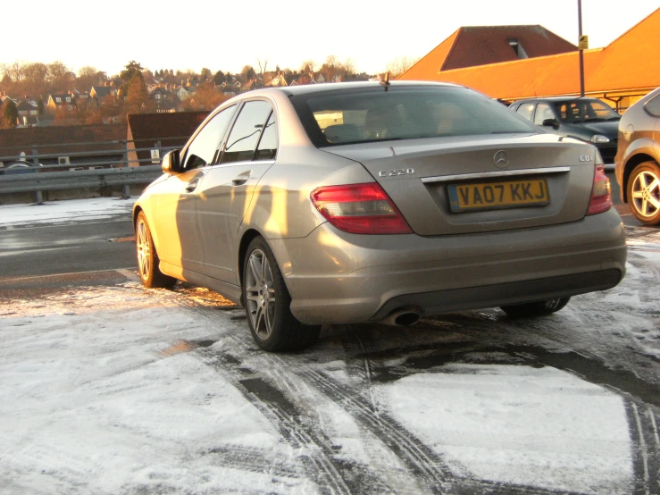 silver mercedes car parked on side of street in snow