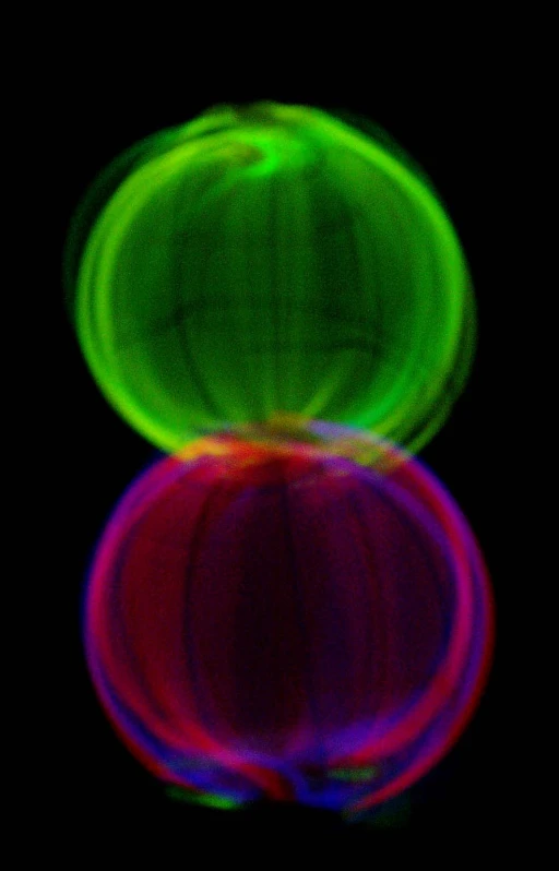 a green, purple, and red object with very blurry lines