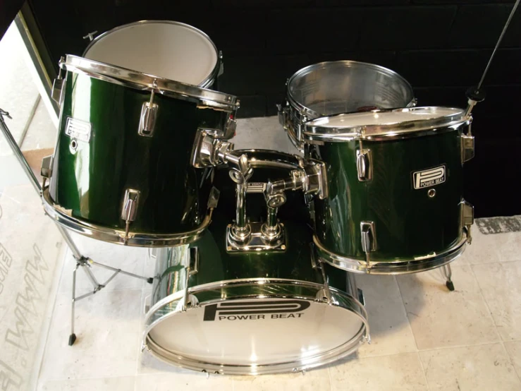 the green set of drums sits on the floor