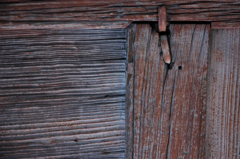 the wooden wall with a latch is very old