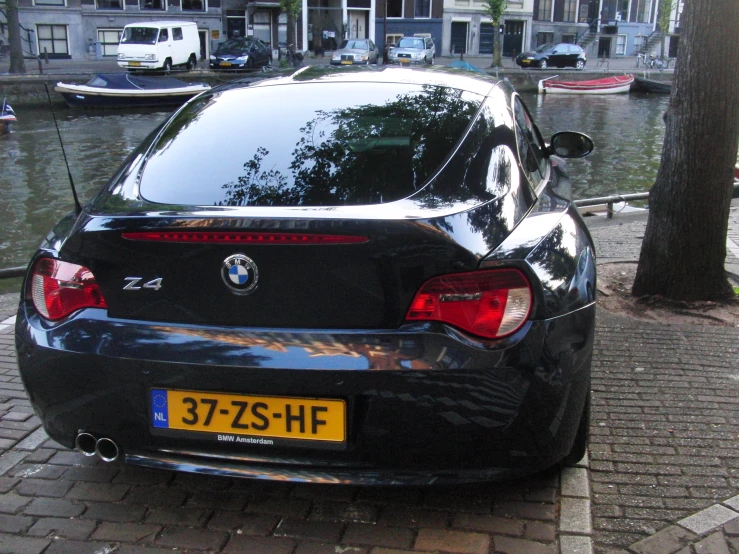 a black bmw car parked by some water