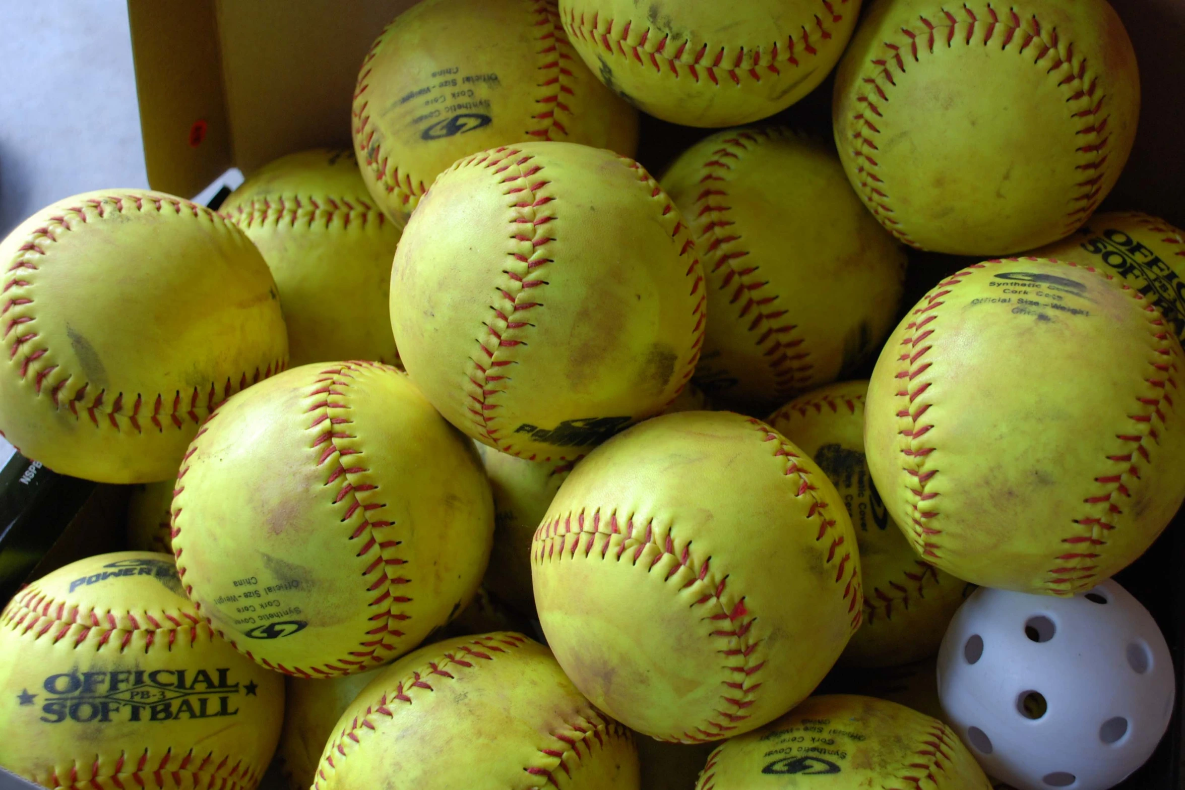 a large bucket filled with baseballs on top of a table