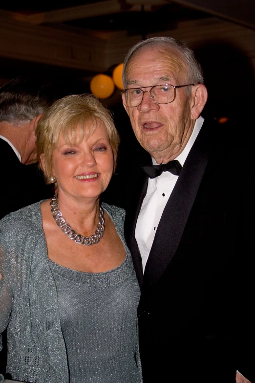 an older gentleman and a younger woman at a formal event