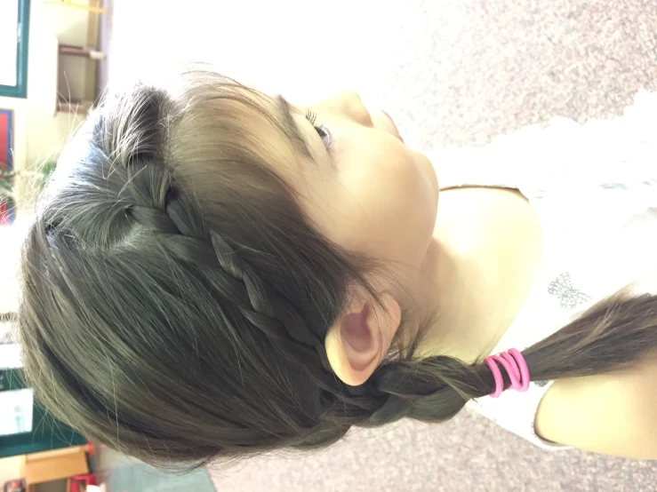 a little girl with a ponytail with one piece pinned back