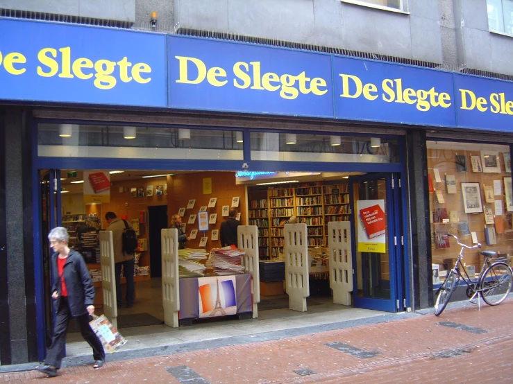 a woman walks out of a bookstore carrying bags