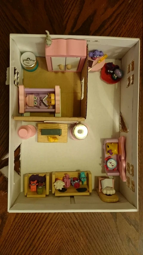 toy doll house made out of wood on wooden floor