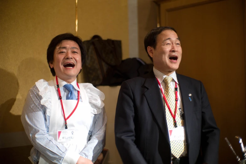 two men that are wearing ties and laughing