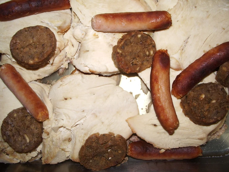 a metal pan filled with different types of sausage