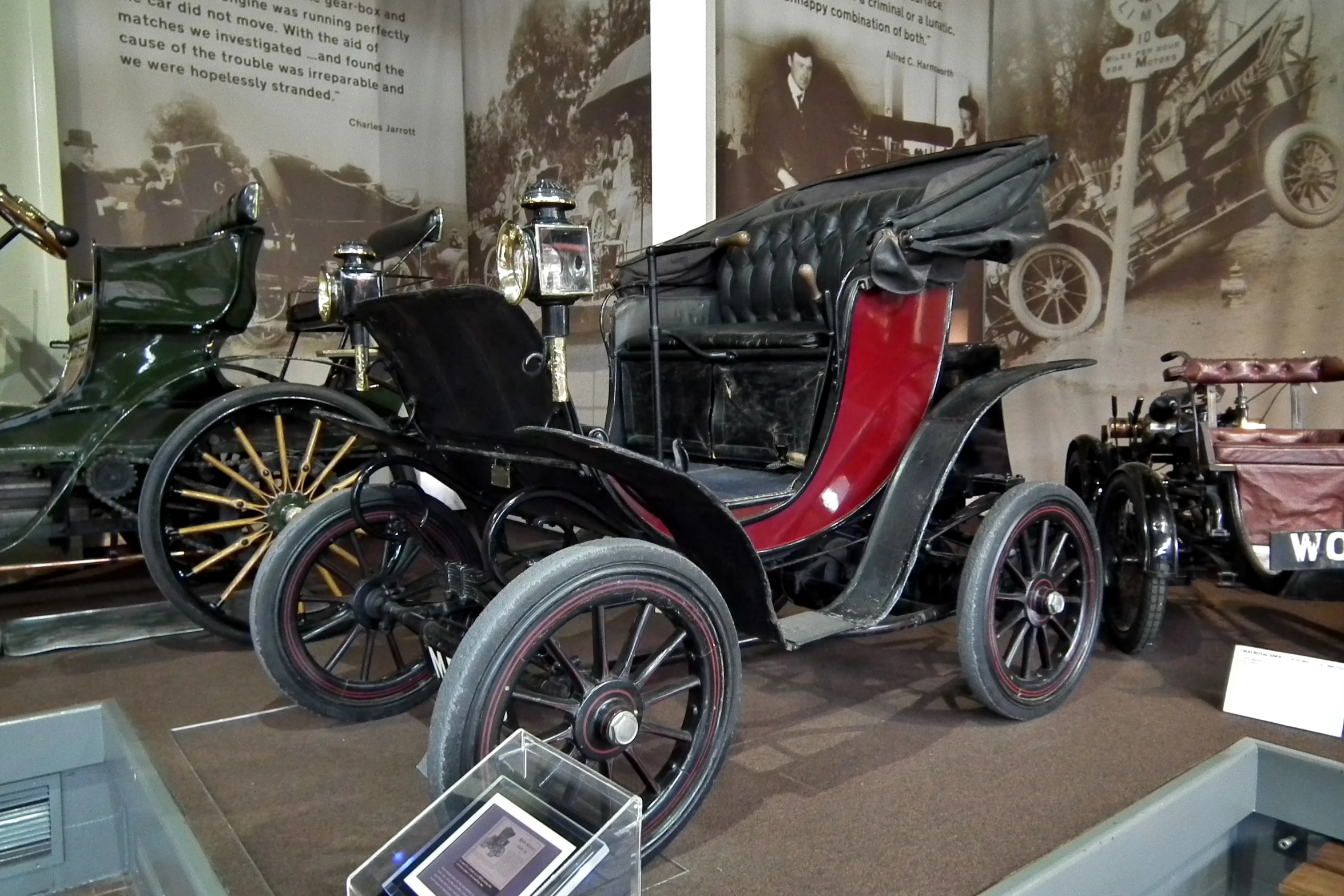 antique cars sit on display in an exhibit