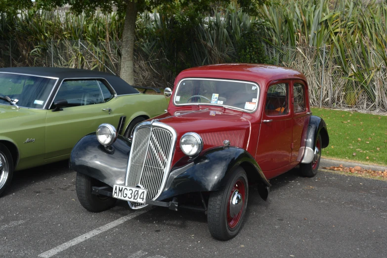 old cars parked in parking lot with trees