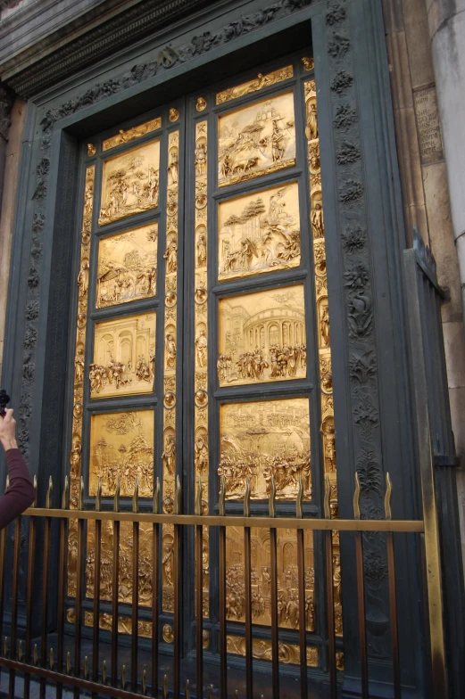 a woman standing by a gate using her cell phone