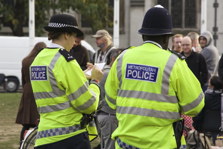 two police officers are writing on their hands