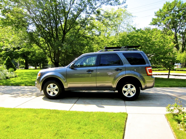 a suv is parked along the curb next to grass